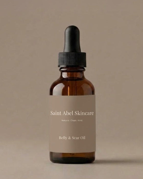An amber glass dropper bottle of Saint Abel Skincare Belly & Scar Oil with a beige label and black dropper cap, set against a solid beige background.